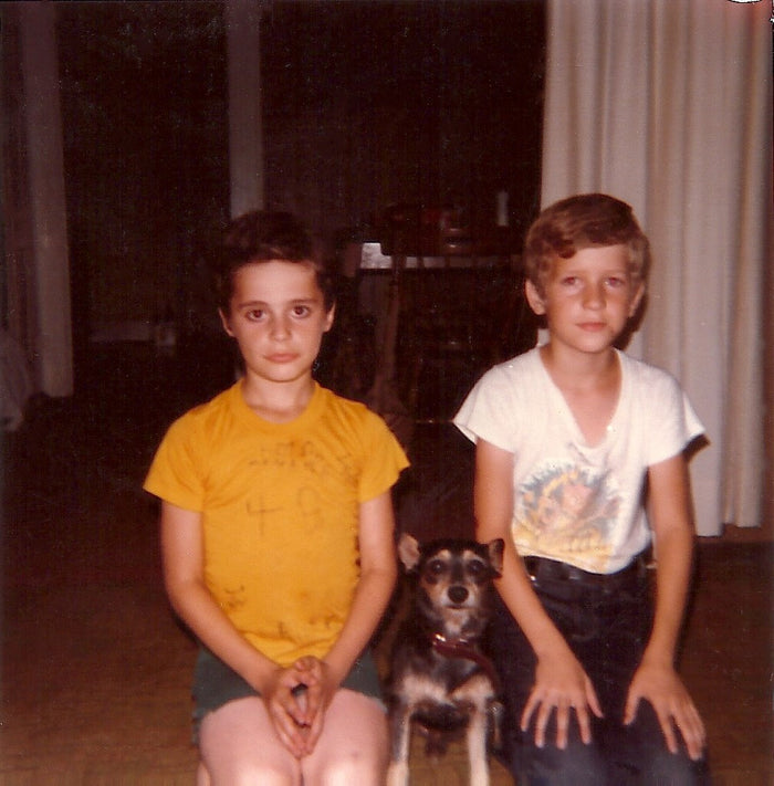 Ricky and Arthur Mills as boys in 1984, sitting with their dog Tiny between them.