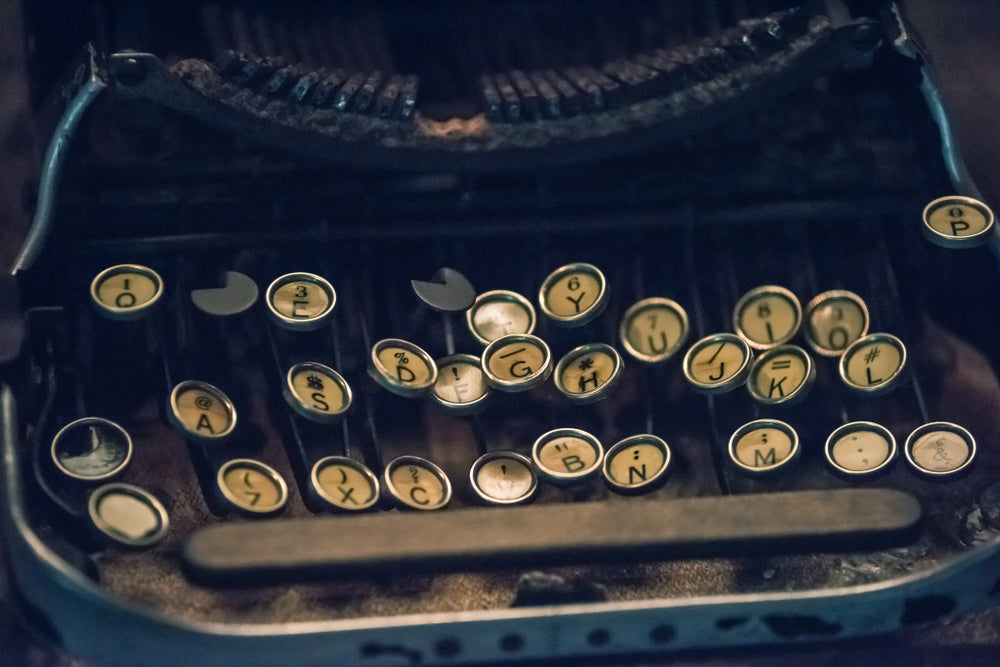 Close-up of a broken antique typewriter's round, worn keys with scattered missing keys.